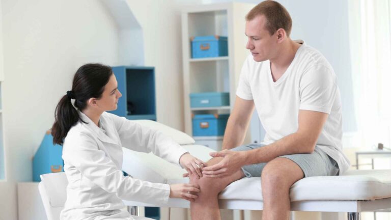 Doctor examining a patient’s knee at Allina Health Centennial Lakes Clinic