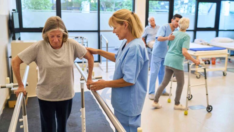 Senior woman receiving physical therapy support from a nurse at Anew Health Care Wauwatosa rehabilitation center.