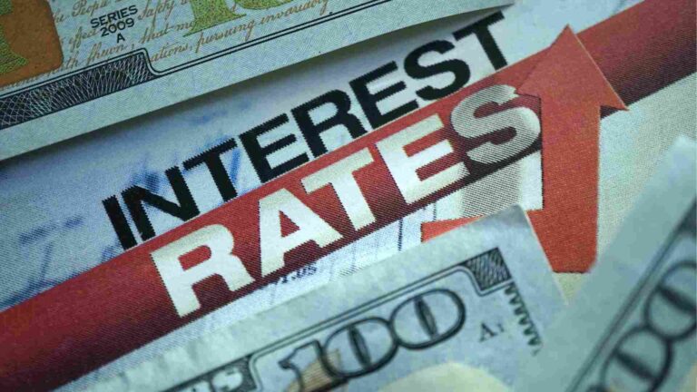 Close-up of U.S. dollar bills with rising interest rates headline