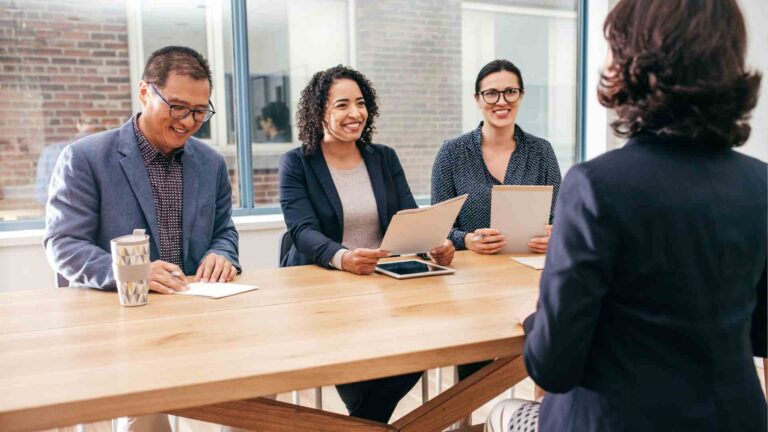 Panel of interviewers asking business analyst questions during an interview session.