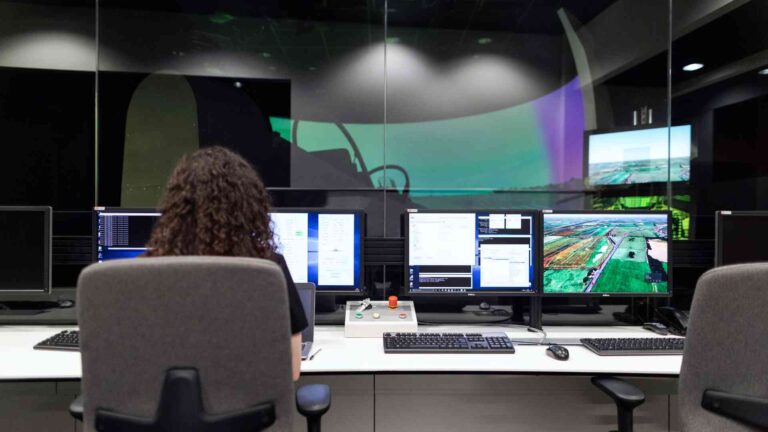 Engineer monitoring multiple screens with advanced computer simulation technology for research and engineering applications.