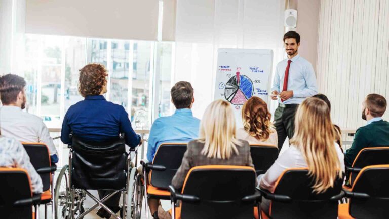 Instructor teaching students during a business administration course with charts and presentations for career-focused learning.