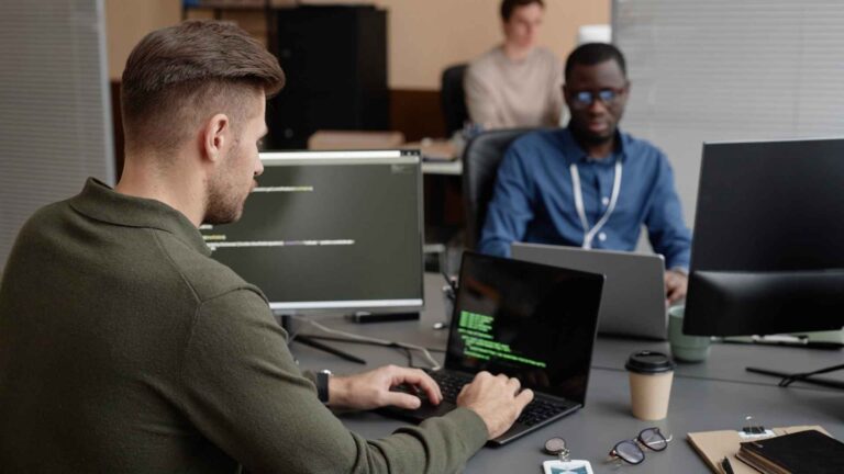 Cybersecurity engineer working on coding and network security at a modern workplace.