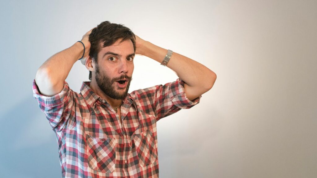 Surprised man holding his head, symbolizing shocking differences between mental vs emotional health