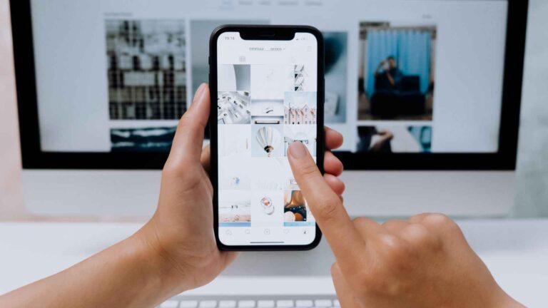 A person using a smartphone while viewing a digital interface — representing how tech giants envision future beyond smartphones through AR, AI, and immersive experiences.