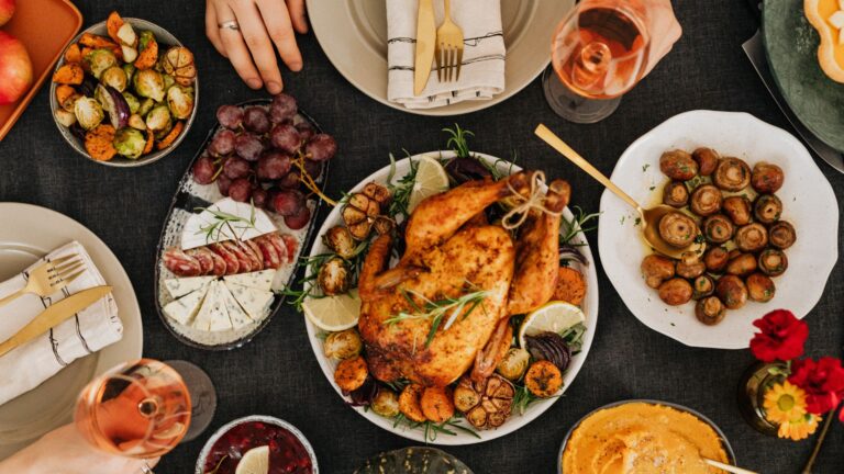 The Best Festival Foods To Elevate Your Celebration Delicious festival foods spread with roasted chicken, cheese platter, grapes, and sides — a perfect celebration feast.