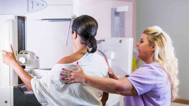 Mammogram technologist assisting patient during breast screening procedure, highlighting mammogram technology salary career field.