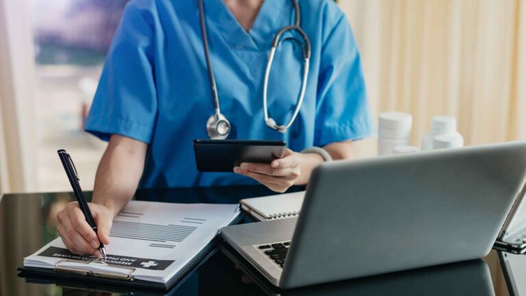 Doctor reviewing patient records on a tablet at Atrium Health Myers Park clinic.