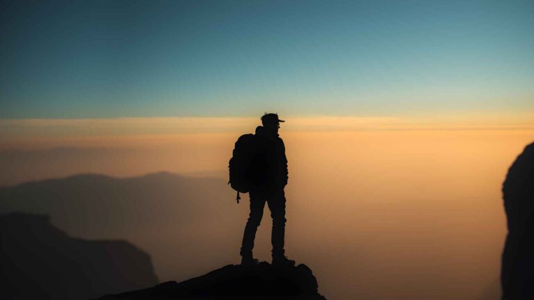 Traveler enjoying sunrise view at one of the best budget travel locations