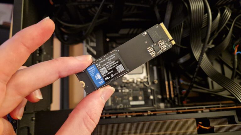 4tb Ssd Buying Guide Reveals The Fastest Drives Yet Person installing a 4TB M.2 NVMe SSD drive into a desktop PC motherboard for ultra-fast storage performance.